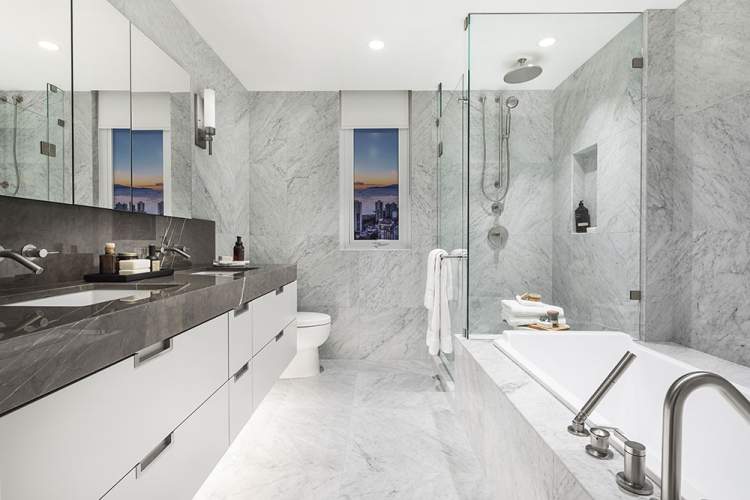 En suites include marble tile, Kohler fixtures and floating wood cabinets.