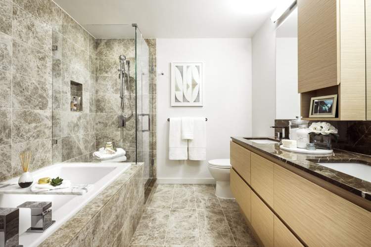 Frameless glass showers, soaker tubs, custom cabinets, and marble-tiled NuHeat floors.