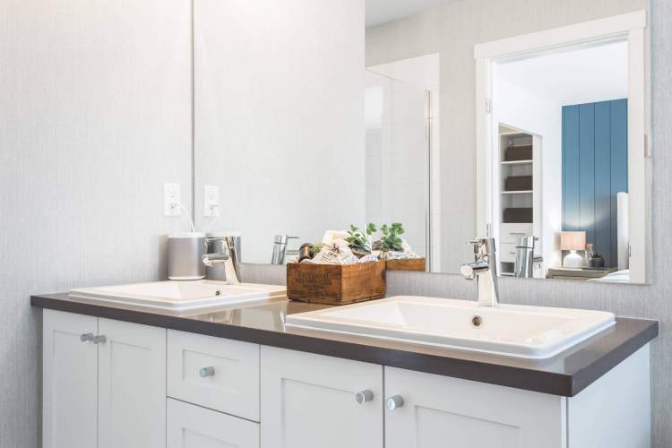 Double sinks with floating vanity, white Shaker cabinetry, and imported quartz countertops make bathrooms beautiful.