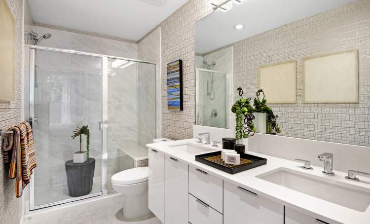 Well-appointed bathrooms with porcelain tile flooring, dual porcelain sinks, and dual-flush toilets.