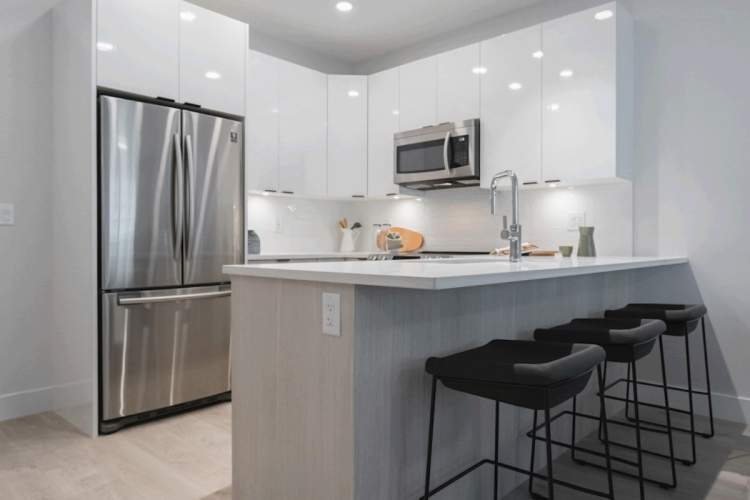 Fitted with granite counters, stainless steel appliances, chrome hardware, and tile backsplash.