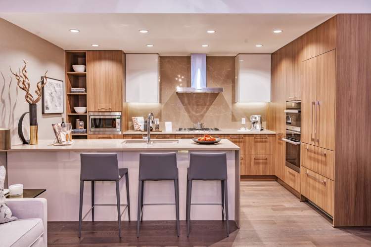 Kitchens feature piano-finish upper cabinet doors and premium European appliances.