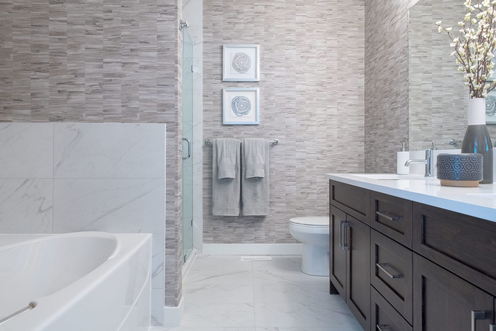 Bathrooms feature deep soaker tubs, Shaker cabinetry, quartz countertops, and chrome faucets.