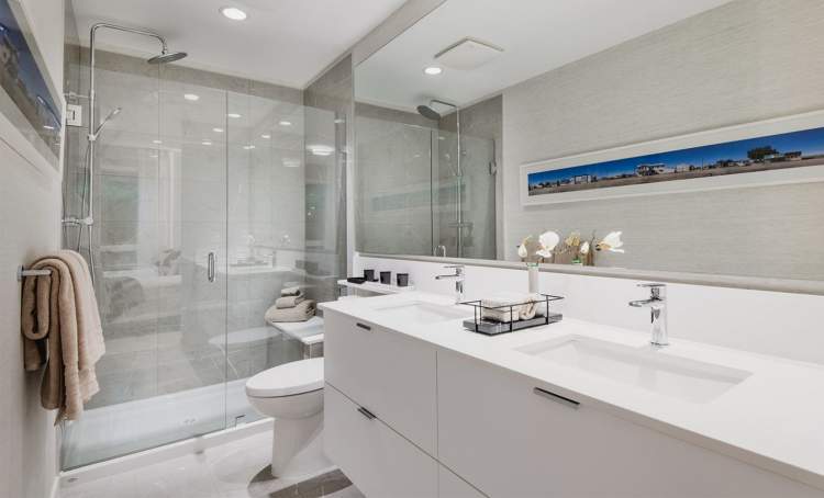 Well-appointed bathrooms with modern flat-panel cabinets, oversized mirrors, and engineered countertops.