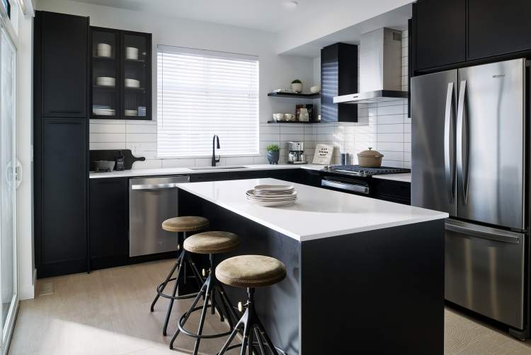 Black or stainless steel appliances and custom soft-close Shaker cabinetry.
